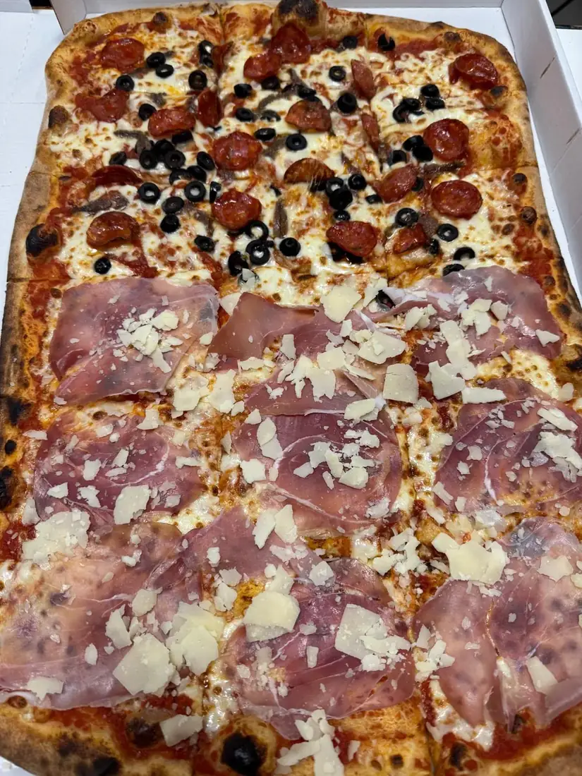 Pizza grande con gusti assortiti e prosciutto crudo